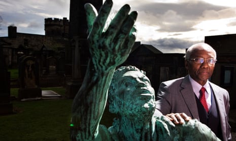 Professor Geoff Palmer, standing beside a statue of a freed slave in the Calton cemetery, Edinburgh, welcomed the report.