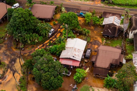 An aerial view of houses with trees and mud surrounding them