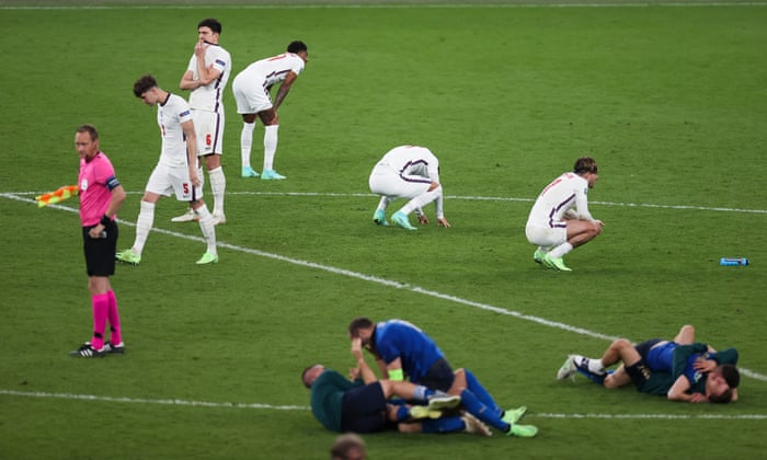 England players dejected as Italy team celebrate winning the penalty shootout.