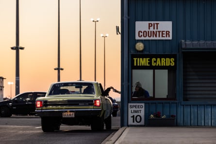 A driver collects their time slip from the pit counter after a run.