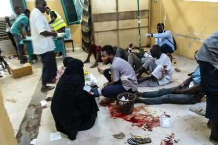 Wounded people lie and sit on a blood-spattered floor in a medical centre