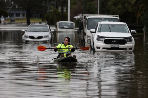 A kayaker paddles through a flooded residential area in South Windsor on Tuesday following heavy rain in Sydney.