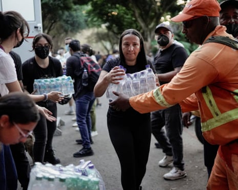 People distribute packs of bottled water in Cali