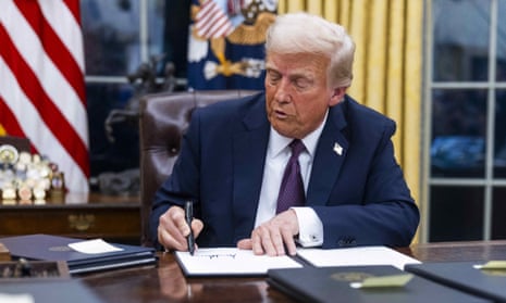 Donald Trump signs an executive order at the Oval Office in Washington DC on 20 January 2025.