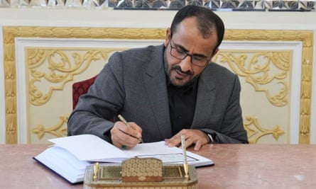 محمد عبدالسلام يوقع كتاباً في حفل رسمي.