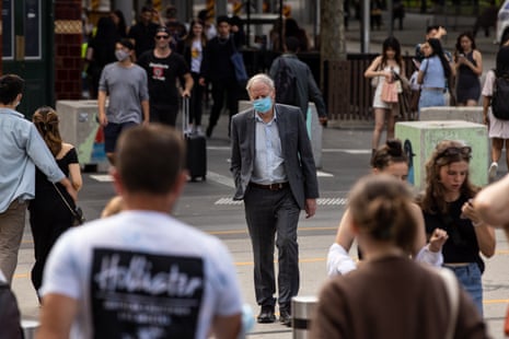 People wearing face masks walk past the Swedish multinational