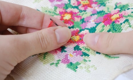 Woman’s hands over cross-stitch embroidery