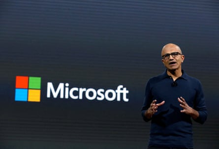 a man speaks next to a backdrop that reads ‘Microsoft’