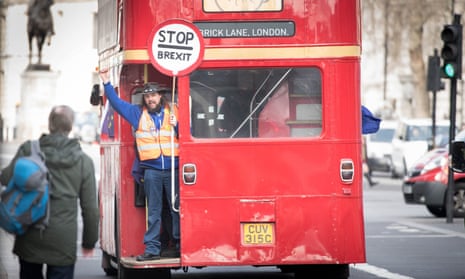 A man holds a ‘Stop Brexit’ sign aboard a double-decker campaign bus travelling down Whitehall in Westminster, London