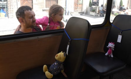 A girl looks into an empty school bus with the stuffed toys.