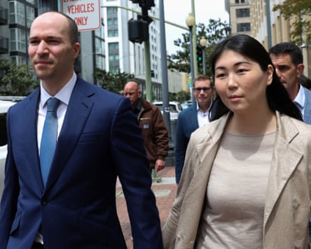 Man and woman holding hands and walking on a sidewalk.