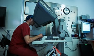 Greg Shaw controls  the robot as it operates on a patient