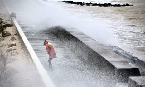 A woman is splashed by the waves on the Quai du Lazaret near the Port des Minimes in La Rochelle, centre-western France, on November 2, 2023, as the storm Ciaran hits the region.