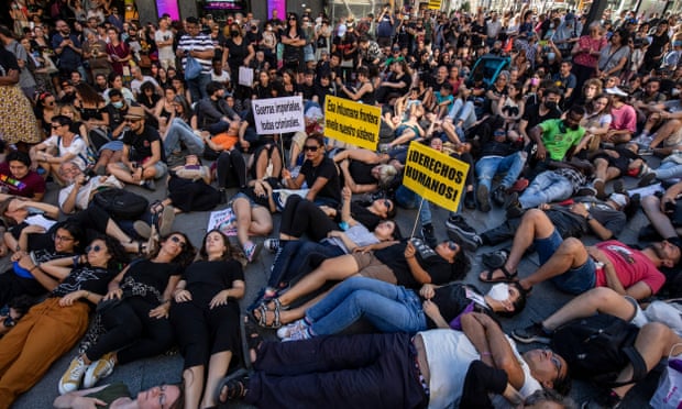 People lie on the ground during a protest in Madrid on Sunday ofter the Melilla border deaths