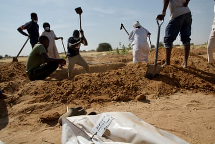 People dig in ground along a dirt road.