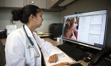 A doctor consults a patient on a computer via a telehealth appointment