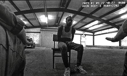A black and white image from a police bodyworn camera video showing a man who alleges he was badly beaten by officers inside their so-called Brave Cave torture warehouse in Baton Rouge, Louisiana.