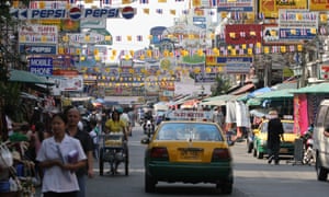 A taxi drives down busy Khao San Road, Bangkok, Thailand.