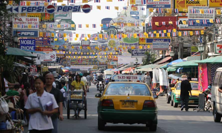 A taxi drives down busy Khao San Road, Bangkok, Thailand.