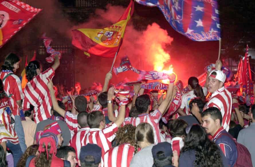 Atleti fans celebrate winning the second division at the Neptune Fountain.