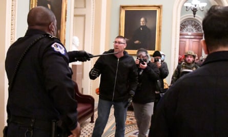 Police confront Trump supporters on the second floor of the US Capitol near the entrance to the Senate after they breached security defenses.