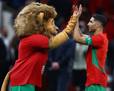 Morocco’s Achraf Hakimi celebrates with the mascot after winning the semi-final in the penalty shootout against Nigeria.