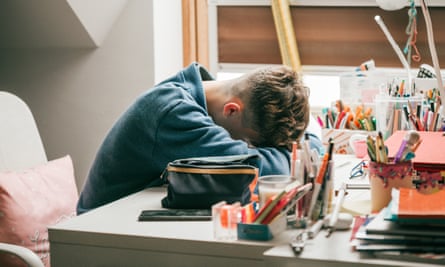 Boy laying his head on a desk 