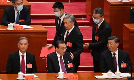 Chinese President Xi Jinping (right) watches former President Hu Jintao (centre) touch the shoulder of Premier Li Keqiang (second from left) as he leaves the closing ceremony of the 20th Congress of the Communist Party of China in the Great Hall of the People.
