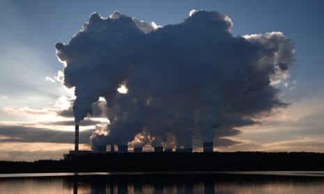 Smoke and steam billow from the chimneys of a power station
