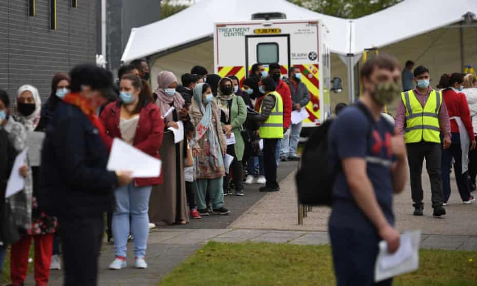 People queue at a temporary Covid-19 vaccination centre in Bolton, north-west England.