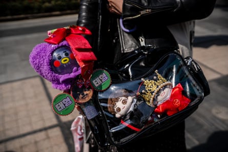 A person carries BTS merchandise and inspired goods and a K-pop light stick