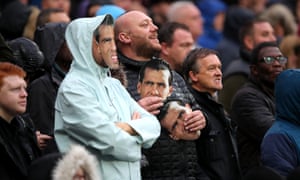 Some West Ham fans taunt the visiting fans with Carlos Tevez masks.