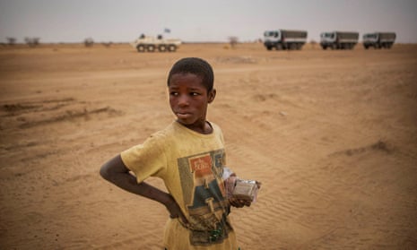 A UN peacekeeping mission convoy passes a boy in Mali’s Gao region