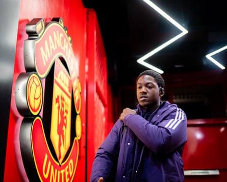 Kobbie Mainoo getting ready to sit on the Manchester United bench, earlier.