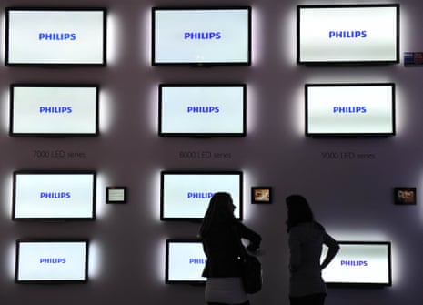 people standing in front of tvs with Philips logo on
