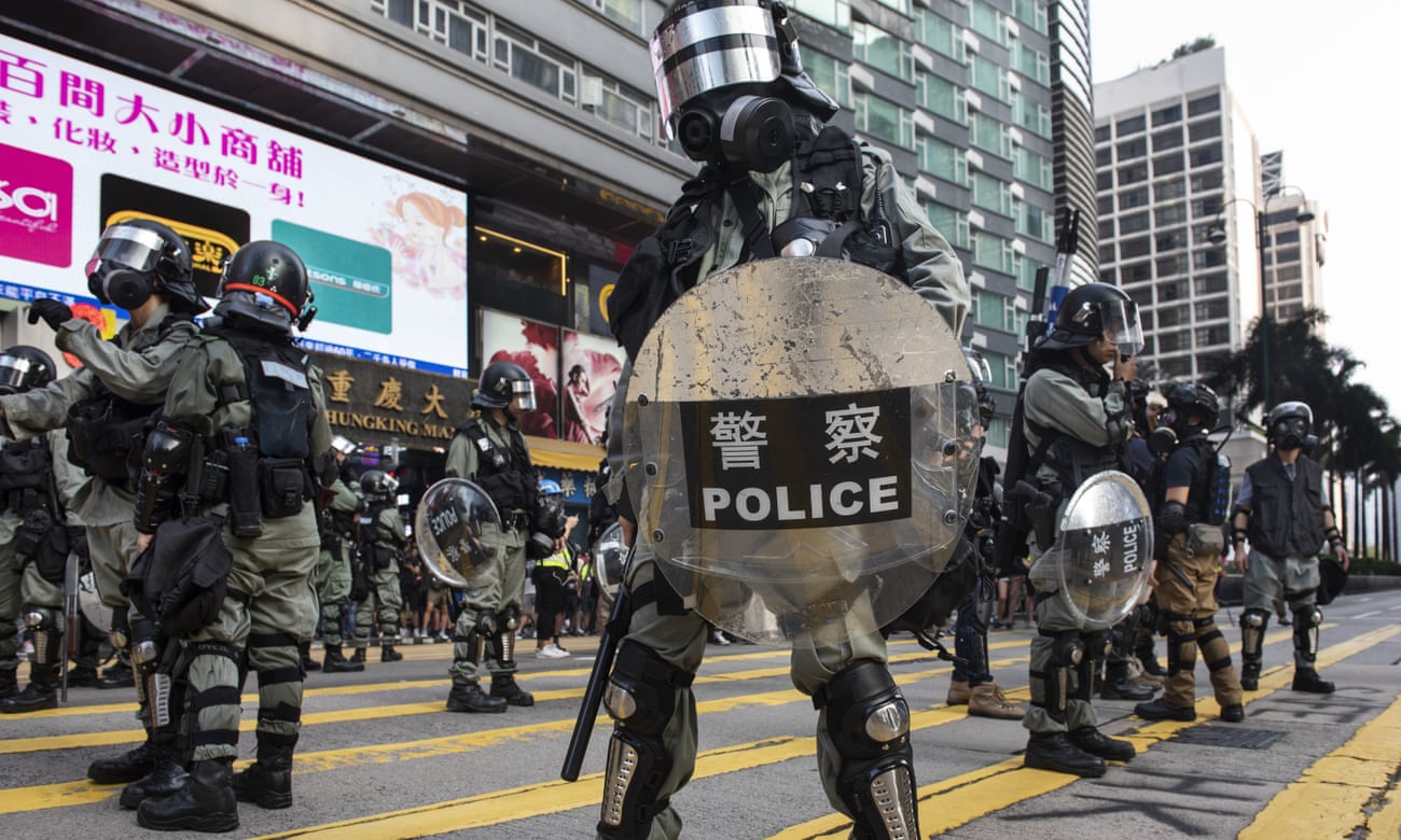 Security forces stand guard as protesters take part in an anti-government protest in Tsim Sha Tsui, Hong Kong