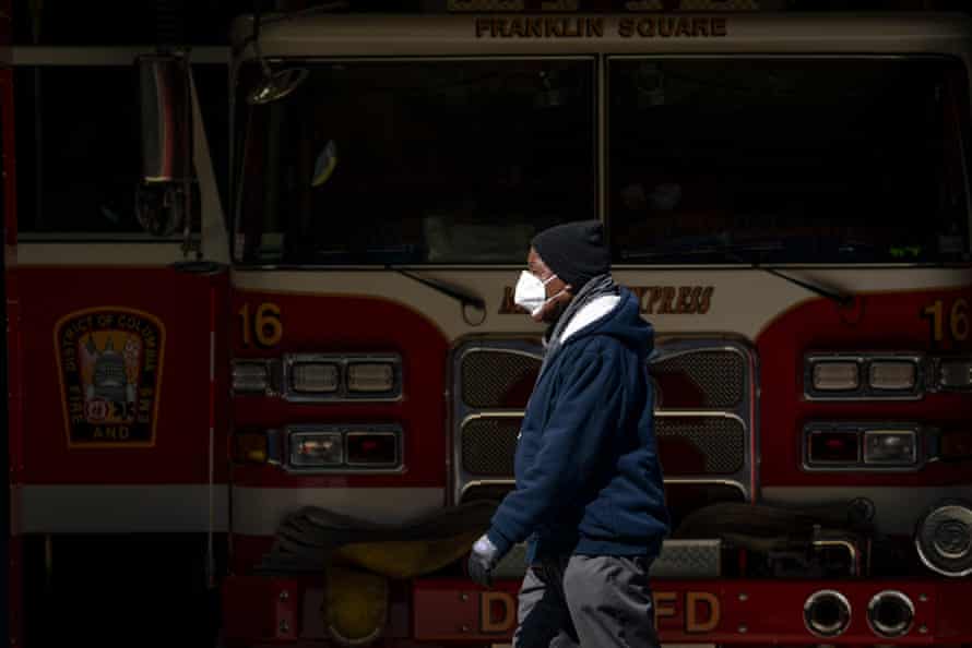 A man wearing a face mask walks past the Franklin Square fire station on April 7, 2020 in Washington, DC. More than 430 employees from the District of Columbia Fire Department and Metropolitan Police Department were quarantining due to potential coronavirus exposure. As of Monday, 34 members of the fire department, including an assistant fire chief, have tested positive for COVID-19.