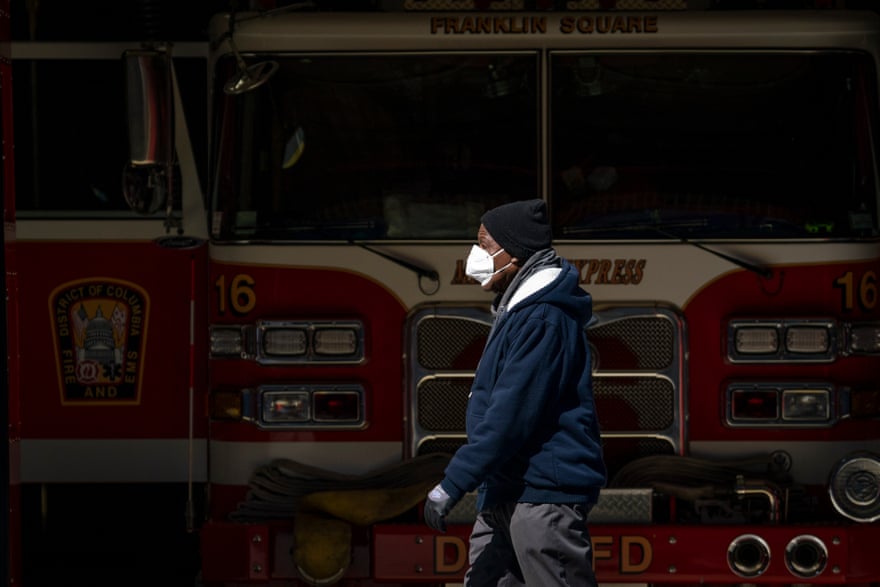 A man wearing a face mask walks past the Franklin Square fire station on April 7, 2020 in Washington, DC. More than 430 employees from the District of Columbia Fire Department and Metropolitan Police Department were quarantining due to potential coronavirus exposure. As of Monday, 34 members of the fire department, including an assistant fire chief, have tested positive for COVID-19.
