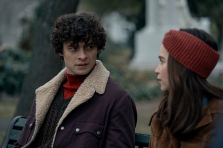 A man in a jacket with a fleece edge and a woman with long dark hair wearing a burgundy head warmer