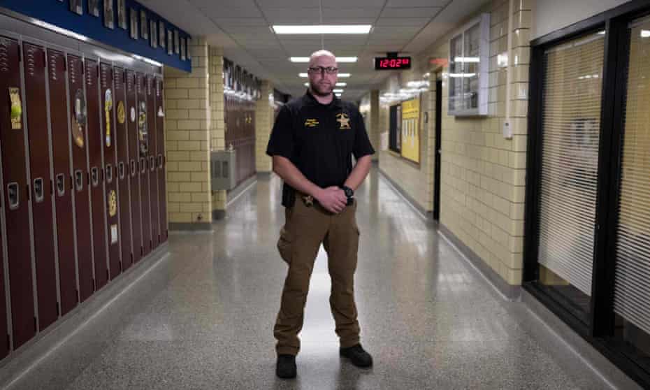 An armed school safety officer patrols Sidney high school in rural Sidney, Ohio, 31 October 2019. 