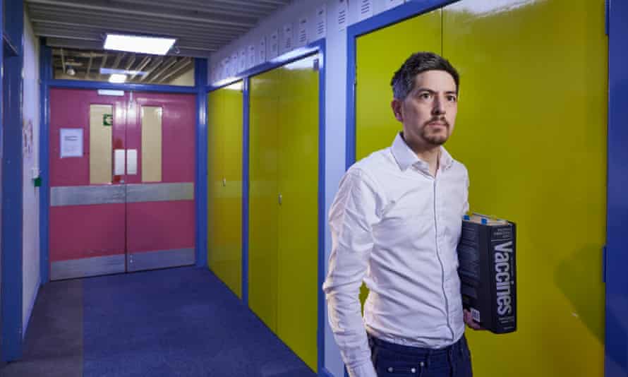 UKHSA epidemiologist Conall Watson, carrying a vaccines book in a corridor