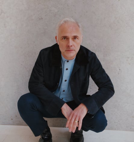 Mark Bonnar crouching down, wearing suede jacket and trousers both by berluti.com; shirt by to.ast; boots by hermes.com.
