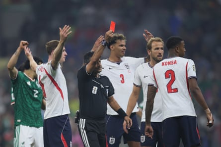 Surrounded by England players, Alireza Faghani shows a red card