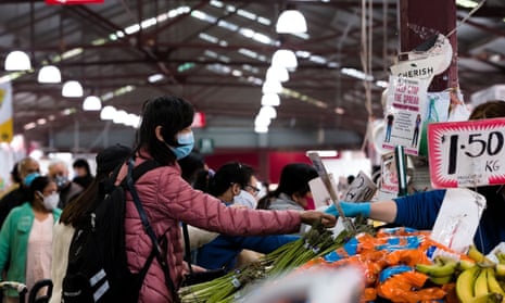 A woman pays for groceries at the Queen Victoria Market in Melbourne.