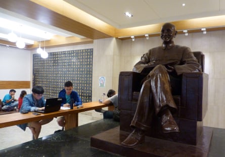 Tapei students work in the shadow of a statue of the late Taiwan leader Chiang Kai-shek