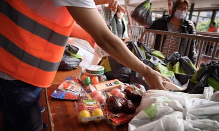 Volunteers hands out food bags at a free distribution point for the people in need in Geneva.