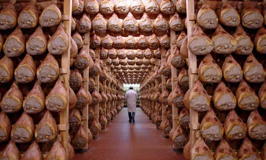 A worker walking in a special room where Parma ham is hung to dry in Langhirano, Italy.