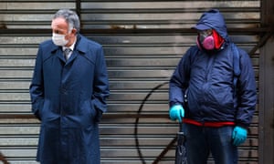 People wearing masks line up to collect state bonds or loans to face the economic crisis caused by the coronavirus pandemic on July 8, 2020 in Santiago, Chile.