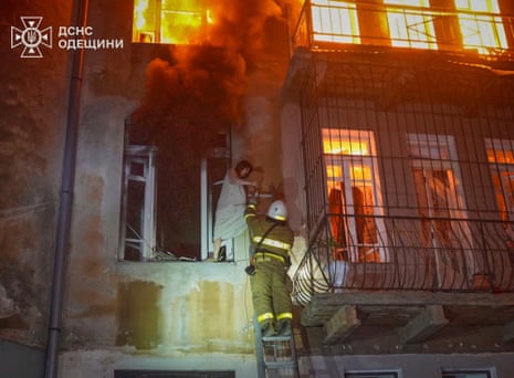 In this photo provided by the Ukrainian Emergency Service, firefighters evacuate a resident from the burning apartment building following Russia’s massive air attack in Odesa, Ukraine.
