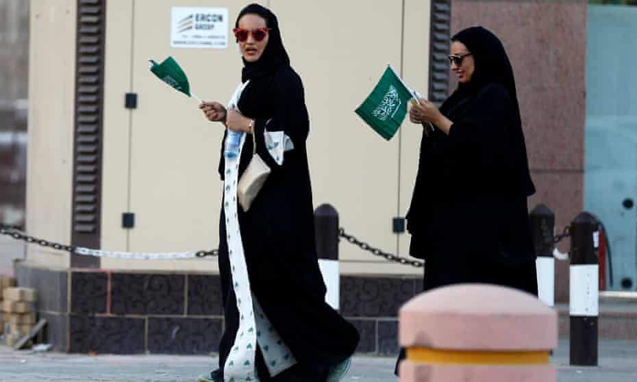Saudi women hold national flags during Saudi National Day in Riyadh, Saudi Arabia Friday.